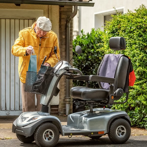 Elder man next to his scooter